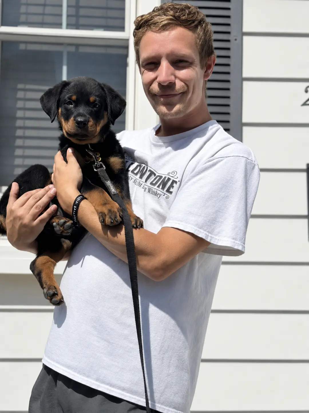 Alex holding Kaiju, his Rottweiler, as a puppy