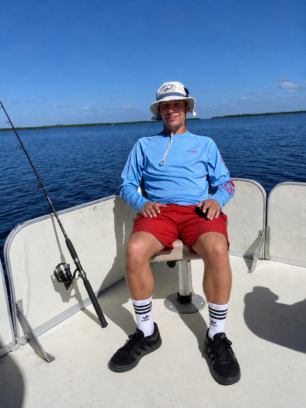 Alex sitting on a fishing boat on open water on a clear day